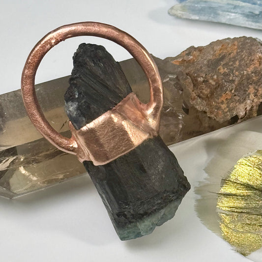 A handmade crystal pendant with copper and tourmaline