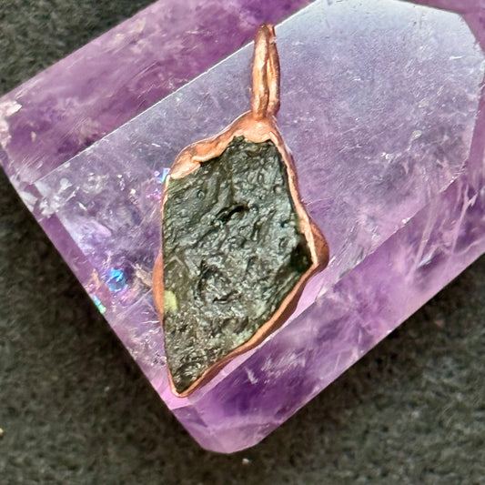 Copper pendant with green stone on a purple crystal