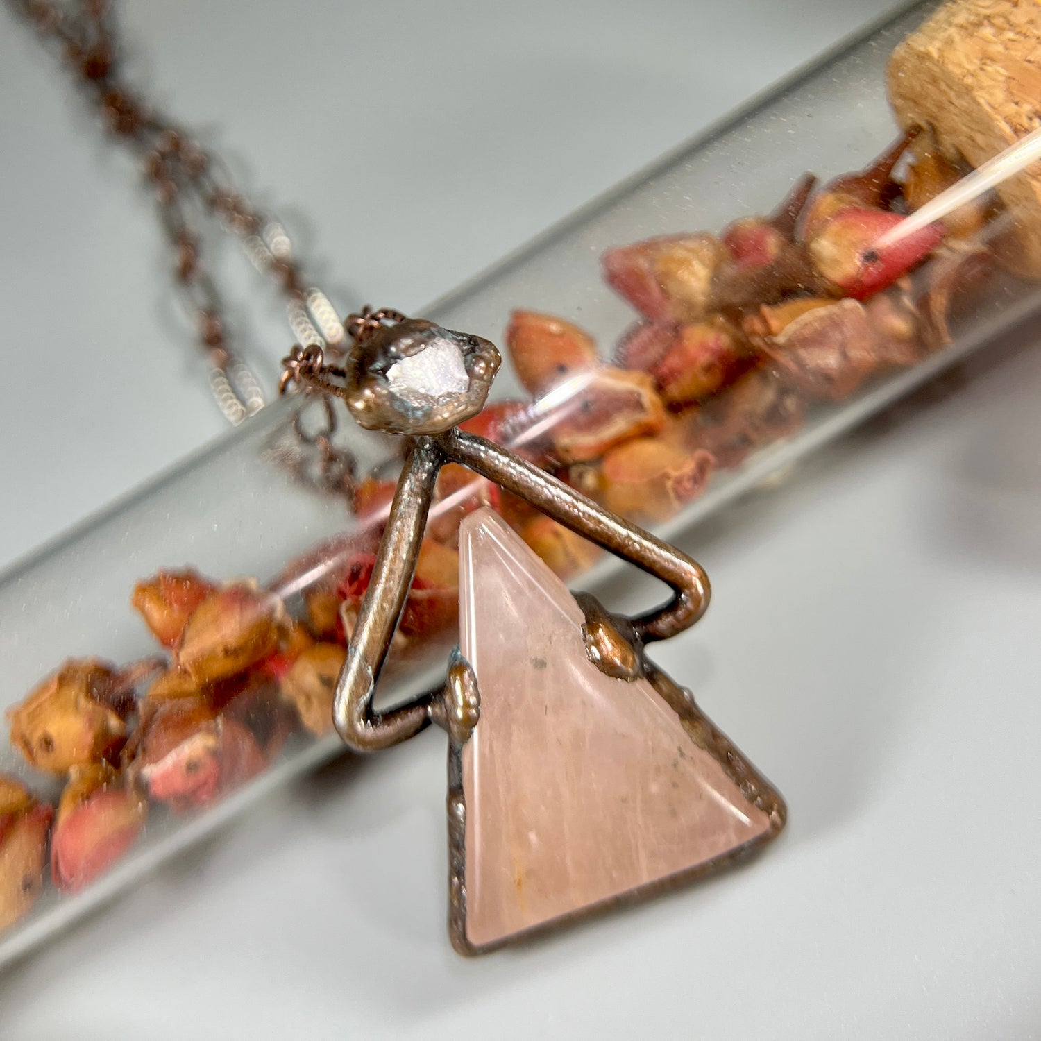 pink rose quartz triangle crystal pendant with a herkimer diamond crystal at the apex.